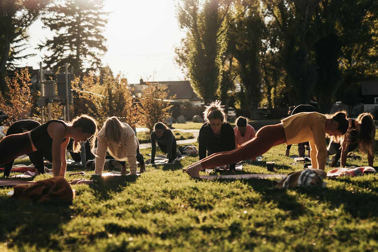 a group of people doing yoga in a park